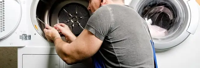 Dryer repair technician fixing a clothes dryer drum in San Antonio, TX