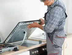 Appliance repair technician installing a built-in cooktop in San Antonio, TX