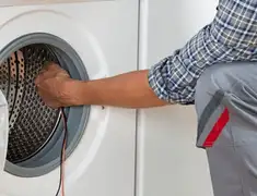 Dryer repair technician diagnosing and servicing a clothes dryer in San Antonio, TX