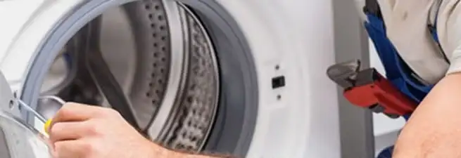 Appliance technician repairing a clothes dryer drum and internal parts in San Antonio, TX