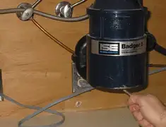 Garbage disposal repair technician tightening the mounting ring under a sink in San Antonio, TX