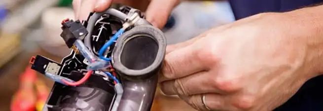 Vacuum repair technician reconnecting wiring and components in San Antonio, TX