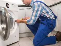 Washing machine repair technician servicing a front-load washer in San Antonio, TX